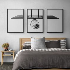 a bed sitting under three framed pictures on the wall