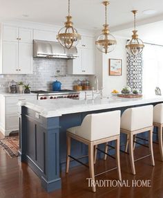 a kitchen island with four stools in front of it