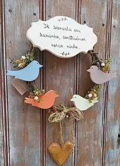 a wreath with birds hanging from it's sides and a sign that says,