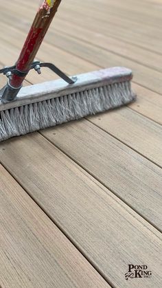 a close up of a broom on a wooden floor