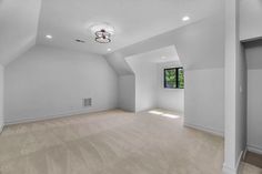 an empty living room with white walls and carpeted flooring is seen in this image