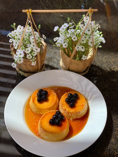 some food is sitting on a white plate with flowers in the vases behind it