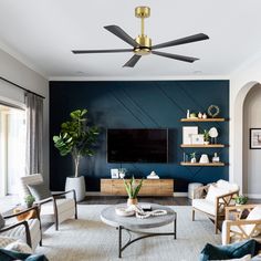 a living room filled with furniture and a flat screen tv mounted on a wall next to a window