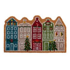 a cross stitch christmas scene with houses and trees on the front, along with other holiday decorations