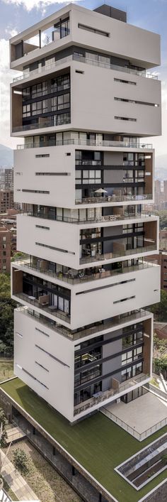 a tall building with lots of windows and balconies on top of it's sides