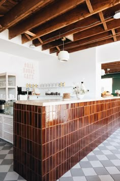 the interior of a restaurant with checkered flooring and wood beams on the ceiling