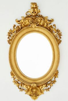 an ornate gold framed mirror against a white wall