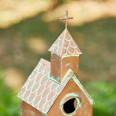 a bird house with a cross on top