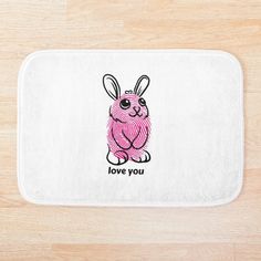 a bath mat with an image of a pink rabbit on it's back and the words love you