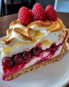 a piece of pie on a plate with raspberries and whipped cream toppings