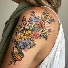 a woman's shoulder with flowers on it and leaves in the middle, all around her