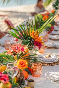 the table is set with orange and pink flowers