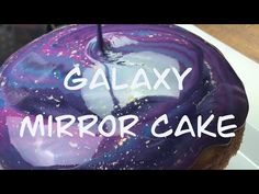 a close up of a cake with the words galaxy in white letters on it and an image of a cupcake