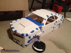 a cardboard car made to look like it's in the process of being built