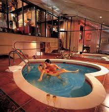 a woman is sitting in the middle of an indoor swimming pool