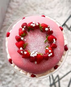 a pink cake with strawberries on top