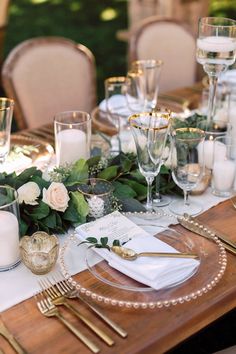 the table is set with candles, plates and napkins