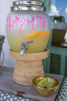 a margarita machine sitting on top of a table next to a bowl of limes