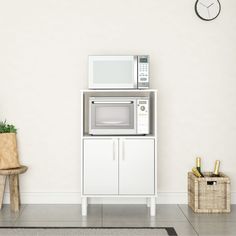 a white microwave oven sitting on top of a cabinet next to a potted plant