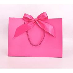 a pink shopping bag with a large bow on it