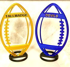 two plastic footballs with the name tailmade and devil's written on them