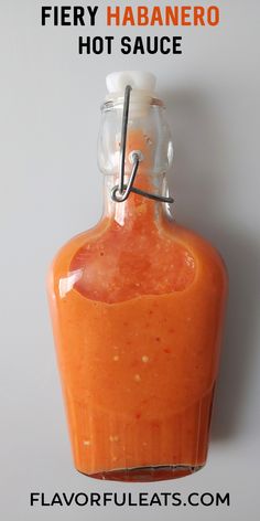 a bottle of hot sauce sitting on top of a white surface with the words fiery habanero written above it