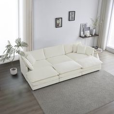 a large white couch sitting in a living room on top of a hard wood floor