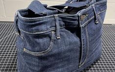 an old pair of blue jeans is sitting on a black mat with a cell phone in it's pocket