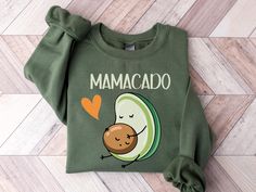 a green sweatshirt with an avocado print on the front, and a heart in the back