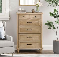 a wooden dresser sitting next to a white chair