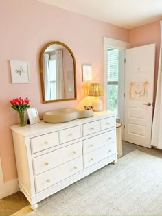 a white dresser sitting in a bedroom next to a window