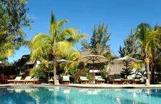 an outdoor swimming pool with lounge chairs and umbrellas