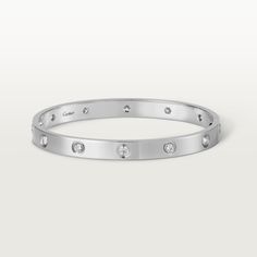 Cartier - LOVE bracelet, 10 diamonds - Bracelet White gold/Gold - LOVE bracelet, white gold 750/1000, set with 10 brilliant-cut diamonds totaling 0.96 carats. Comes with a screwdriver. Width: 6.1 mm. Created in New York in 1969, the LOVE bracelet is an icon of jewelry design: a close fitting, oval bracelet composed of two rigid arcs which is worn on the wrist and removed using a specific screwdriver. The closure is designed with two functional screws placed on either side of the bracelet: you wi Cartier Love Bracelet Diamond, Trinity Bracelet, Bracelet White Gold, Bracelet Love, Detailed Jewelry, Diamond Bangles Bracelet, Love Bracelet, Diamond Bangle, Bracelet Collection