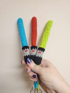 two crocheted carrots are being held by a hand