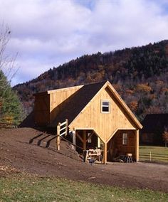 a horse barn in the middle of an open field