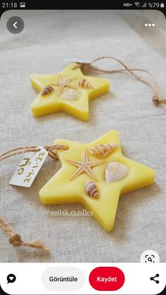 two yellow star shaped candles with seashells on them