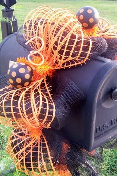 a mailbox decorated with orange and black polka dot decorations on the front of it