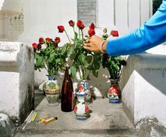 a person is arranging flowers in vases on the steps