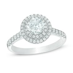 a white gold ring with an oval cut diamond surrounded by round brilliant pave diamonds