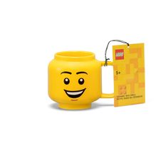 a yellow coffee mug with a smile on it's face next to a card