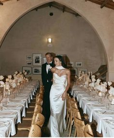 a bride and groom posing for a photo in front of tables with white linens