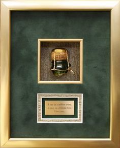 a baseball cap is framed in a green and gold frame with a plaque underneath it