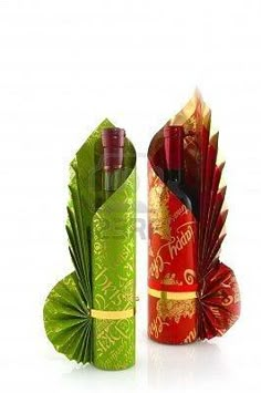 two wine bottles wrapped in green paper with red and gold designs