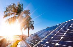 the sun shines brightly behind a solar panel on top of a roof with palm trees in the foreground