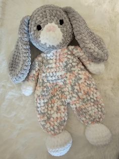 a crocheted bunny laying on top of a white blanket