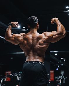 a man flexing his muscles in the gym