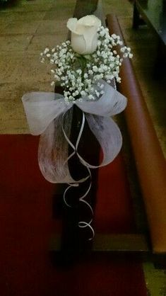 a white rose sitting on top of a black vase filled with baby's breath