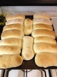 bread rolls are lined up on a baking sheet in the oven, ready to be baked