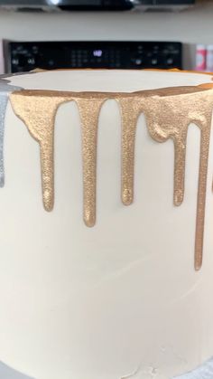 a white cake with gold drips on it