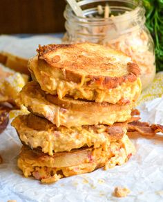 three pancakes stacked on top of each other next to a jar filled with eggs and bacon